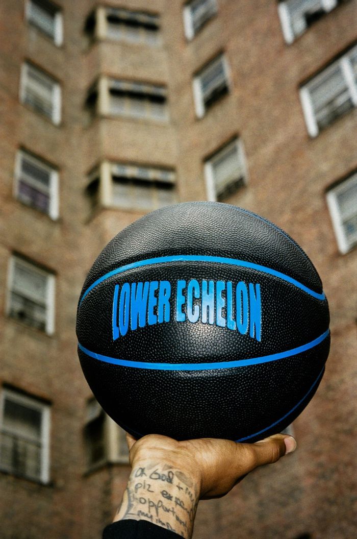 Lower Echelon branded basketball held up against a brick building